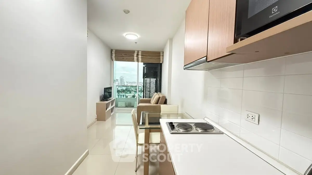 Modern apartment with open kitchen and cozy living area, featuring a city view.