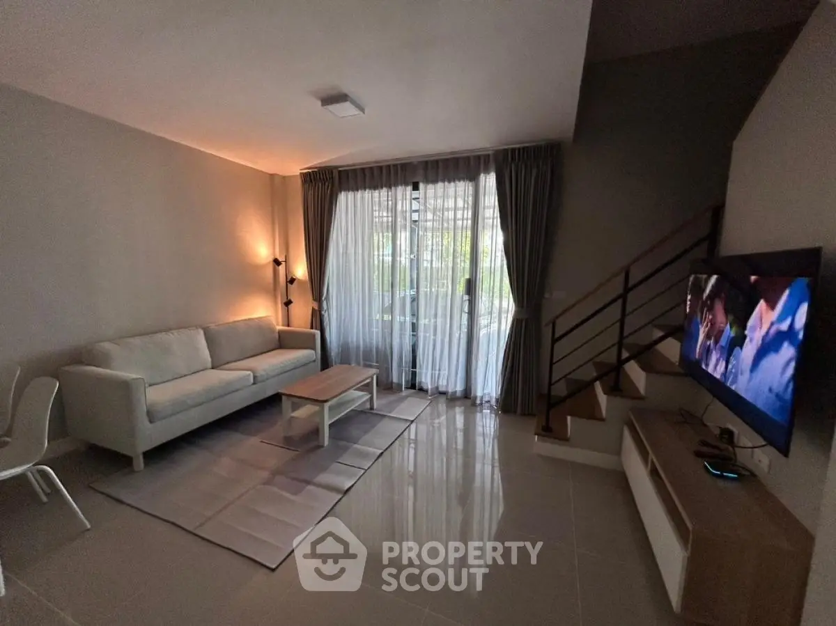 Modern living room with sleek design, cozy sofa, and large TV, perfect for relaxation and entertainment.