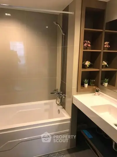 Modern bathroom with bathtub and stylish shelving in a contemporary apartment.