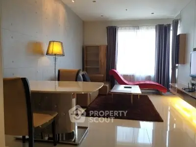 Modern living room with stylish furniture and large window, featuring a unique red chaise lounge.