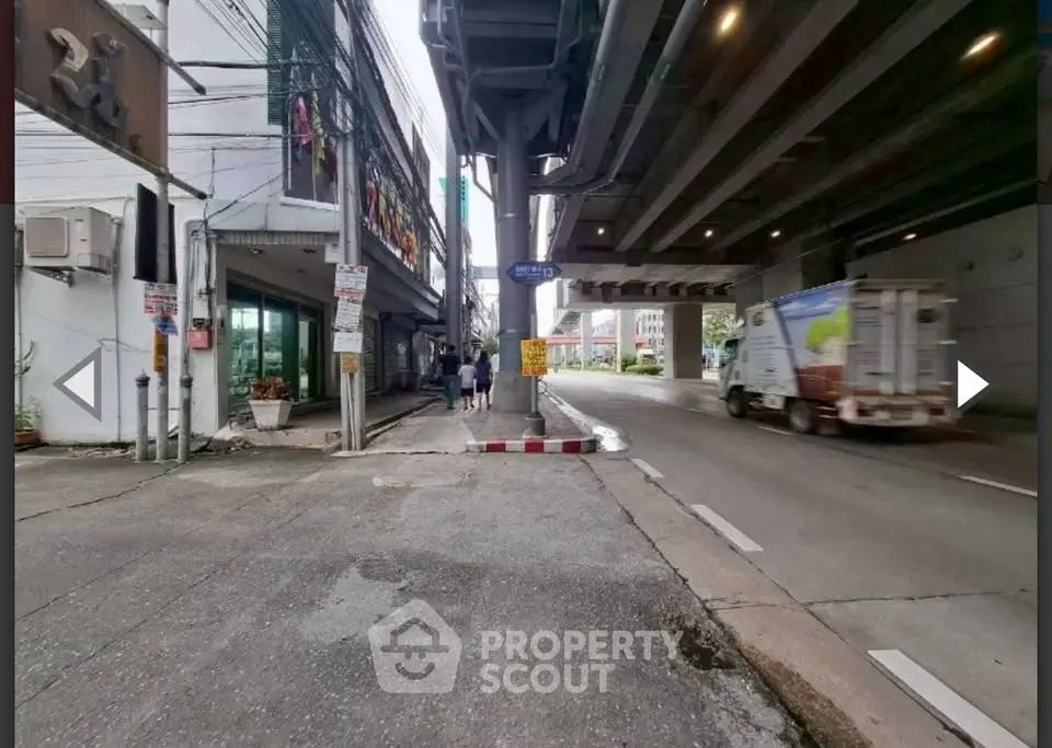 Urban street view with overpass and adjacent buildings, showcasing city infrastructure and road access.