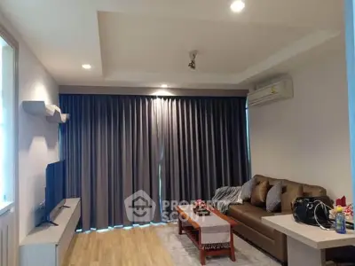 Modern living room with cozy sofa, TV, and elegant curtains in a stylish apartment.