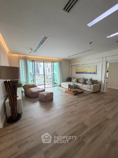 Spacious modern living room with city view, elegant decor, and natural light.