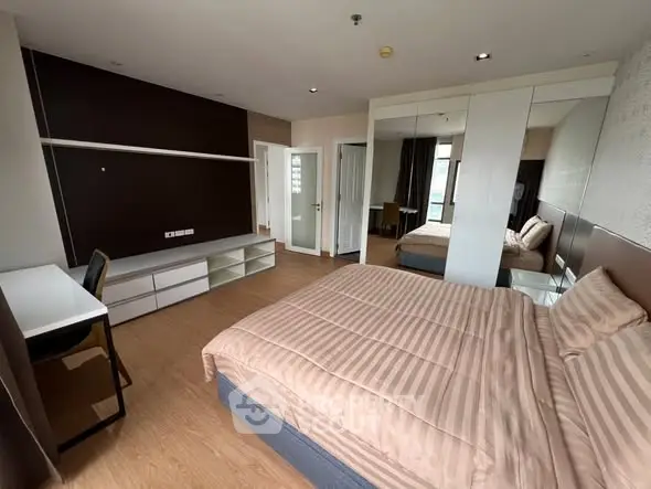 Spacious modern bedroom with elegant decor and ample natural light