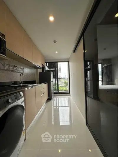 Modern kitchen with sleek appliances and city view from balcony