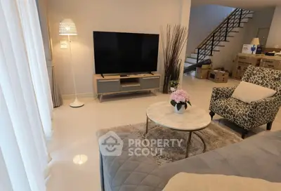 Stylish living room with modern decor, featuring a large TV, elegant furniture, and cozy ambiance.