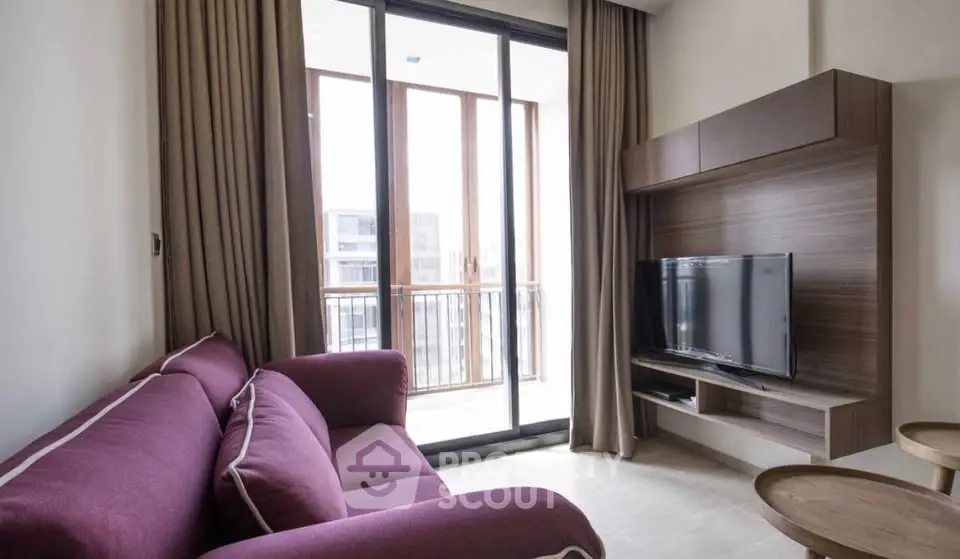 Modern living room with purple sofa and balcony view, featuring sleek TV unit and floor-to-ceiling windows.
