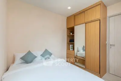 Cozy bedroom with modern wooden wardrobe and comfortable bed