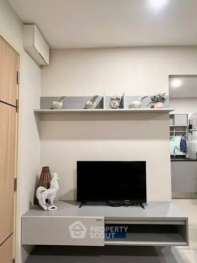 Modern living room with sleek TV stand and decorative shelving in stylish apartment.