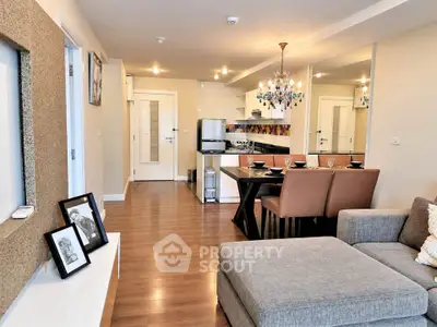 Modern open-plan living room with stylish kitchen and dining area, featuring elegant decor and cozy seating.