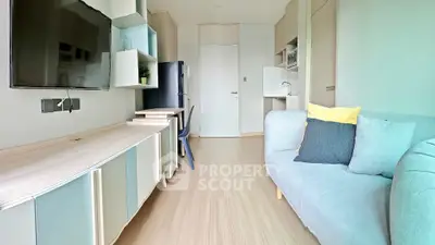 Modern living room with stylish furniture and wall-mounted TV in a cozy apartment.