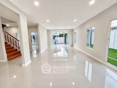 Spacious modern living room with large windows and glossy tile flooring