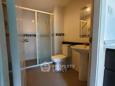 Modern bathroom with glass shower and sleek fixtures in a contemporary apartment.