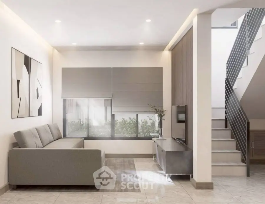Modern living room with stylish decor and staircase, featuring a sleek sofa and contemporary artwork.