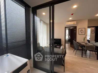 Modern apartment interior with open living and dining area, featuring sleek design and ample natural light.