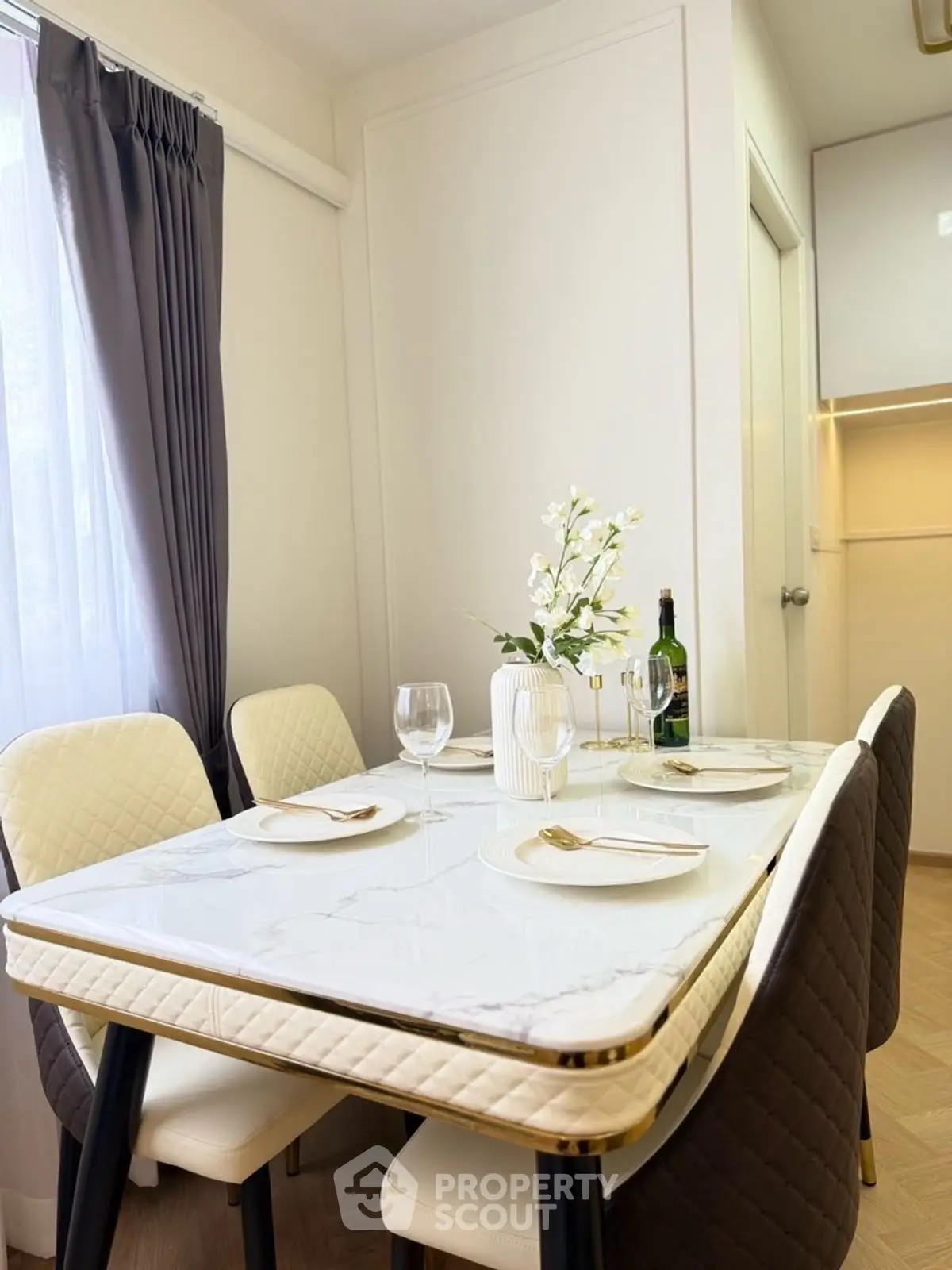 Elegant dining area with marble table and stylish chairs in modern apartment