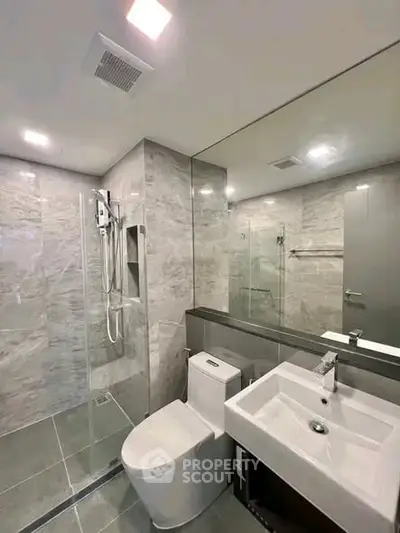 Modern bathroom with sleek design, featuring glass shower and elegant fixtures.