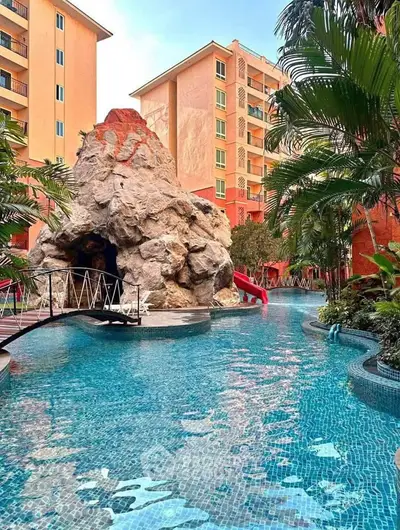 Luxurious apartment complex with stunning pool and unique rock feature, perfect for resort-style living.