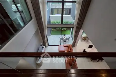 Stunning modern living room with high ceilings and large windows overlooking a private garden.