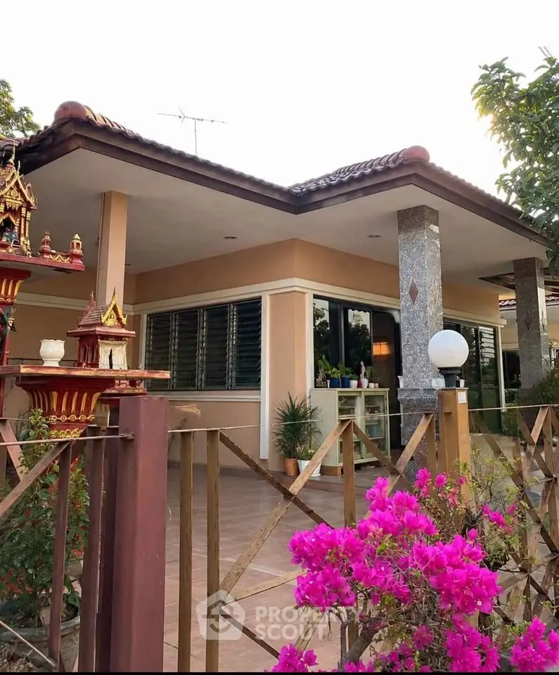 Charming single-story home with lush garden and traditional architectural accents.