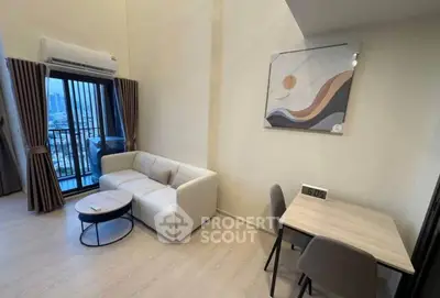 Modern living room with balcony view and stylish decor in high-rise apartment.