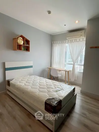 Bright bedroom with modern decor and large window, featuring a cozy bed and study desk.