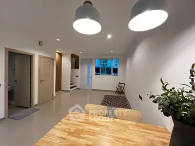 Spacious modern living room with stylish lighting and wooden dining table