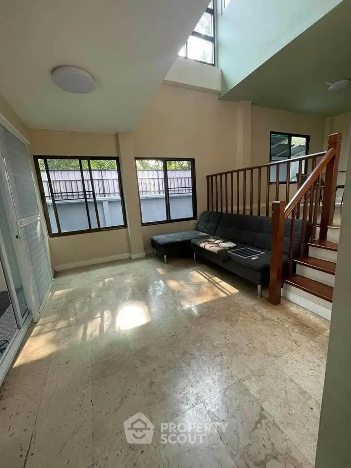 Spacious living room with high ceiling and natural light