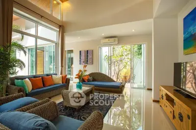 Luxurious living room with elegant decor and large windows offering natural light and garden view.