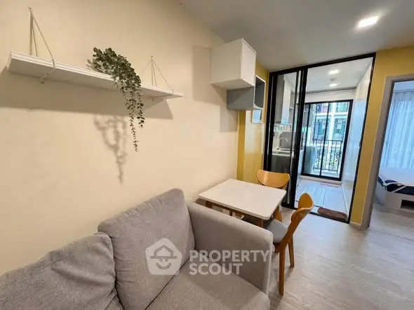 Cozy living room with modern decor and balcony view in a stylish apartment.