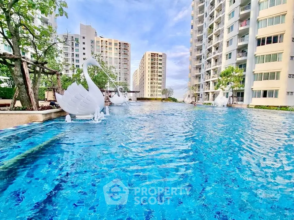 Luxurious apartment complex with stunning pool and swan sculptures, perfect for modern living.