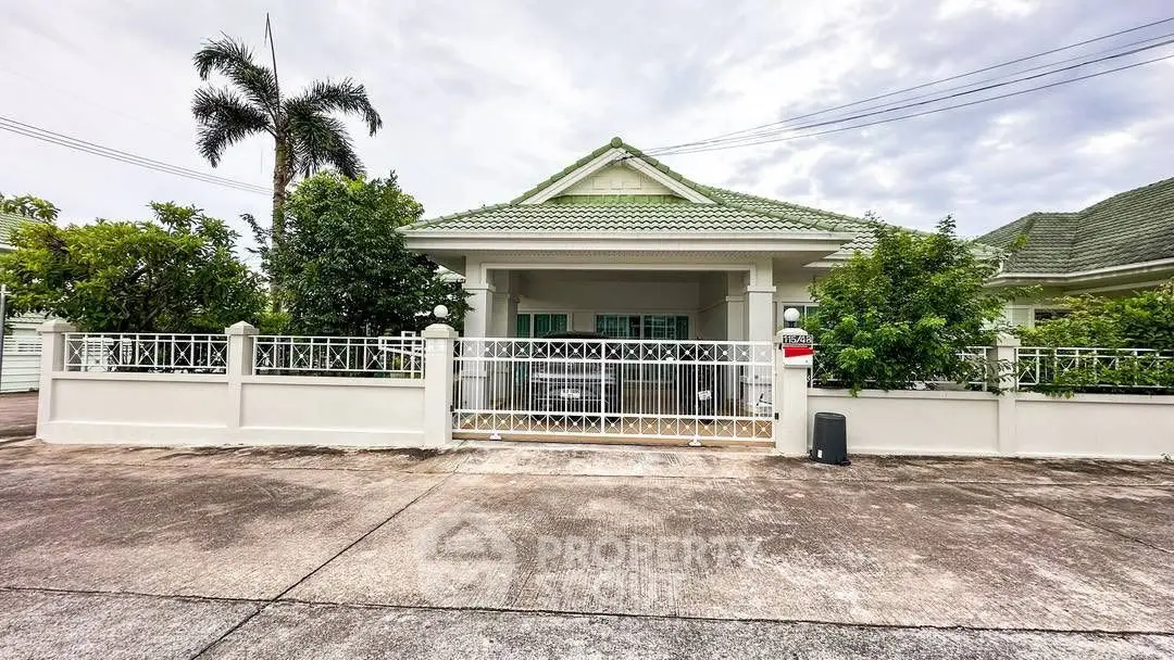 Charming suburban house with lush greenery and secure gated entrance.