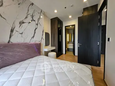 Modern bedroom with marble accent wall and sleek furnishings