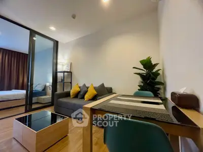 Modern living room with stylish decor and adjacent bedroom in a cozy apartment setting.