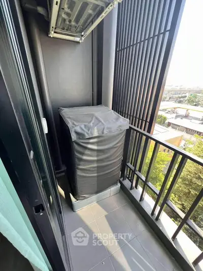 Compact balcony with city view and covered appliance, ideal for urban living.