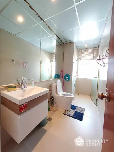 Modern bathroom with sleek fixtures and large mirror in a bright apartment.