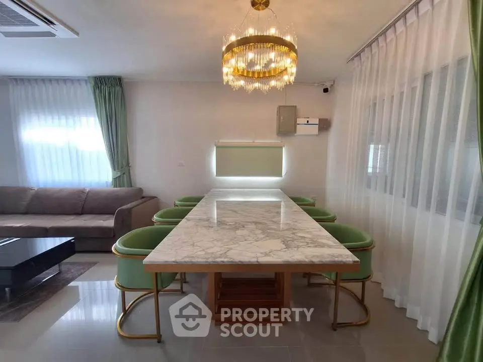 Elegant dining area with marble table and modern chandelier in a stylish living room.