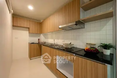 Modern kitchen with sleek wooden cabinetry and built-in appliances, perfect for culinary enthusiasts.