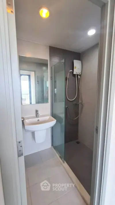 Modern bathroom with glass shower and sleek fixtures in a contemporary apartment.