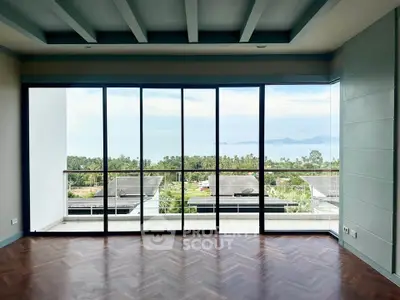 Stunning ocean view from modern living room with floor-to-ceiling windows and elegant parquet flooring.