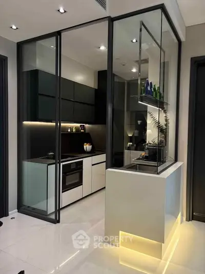 Modern kitchen with sleek design, glass partitions, and under-cabinet lighting in a luxury apartment.