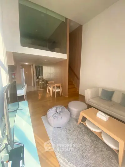 Modern living room with loft, stylish furniture, and natural light