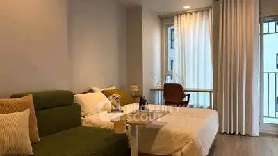 Modern bedroom with cozy bed, study desk, and balcony access in stylish apartment.