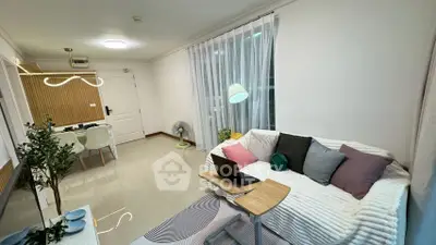 Modern living room with cozy sofa, laptop, and stylish decor in a bright apartment.