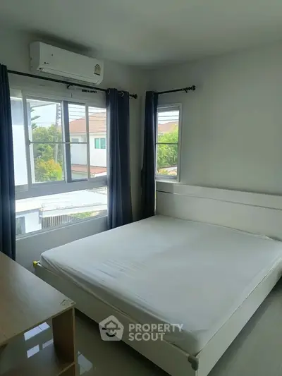Bright bedroom with large windows and air conditioning unit