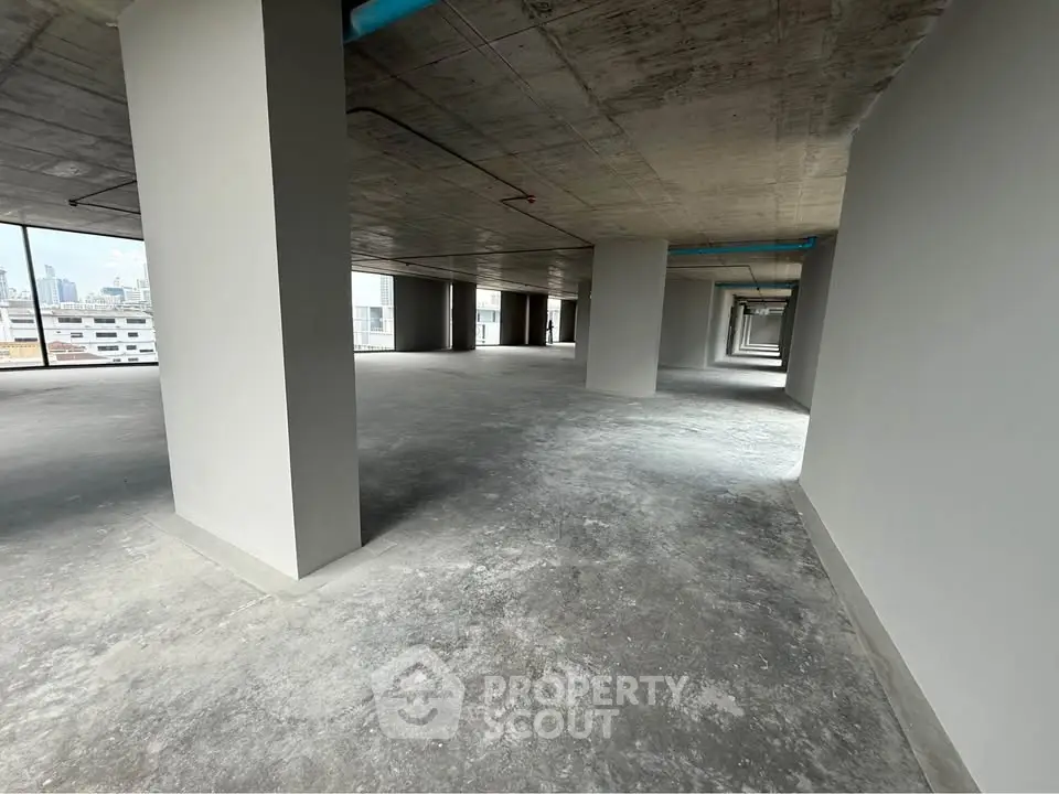 Spacious open-plan commercial space with concrete floors and ceiling, ideal for customization.