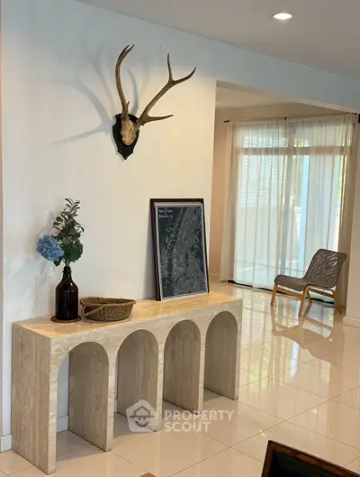 Stylish living room with modern decor and natural light, featuring a unique console table and elegant wall art.