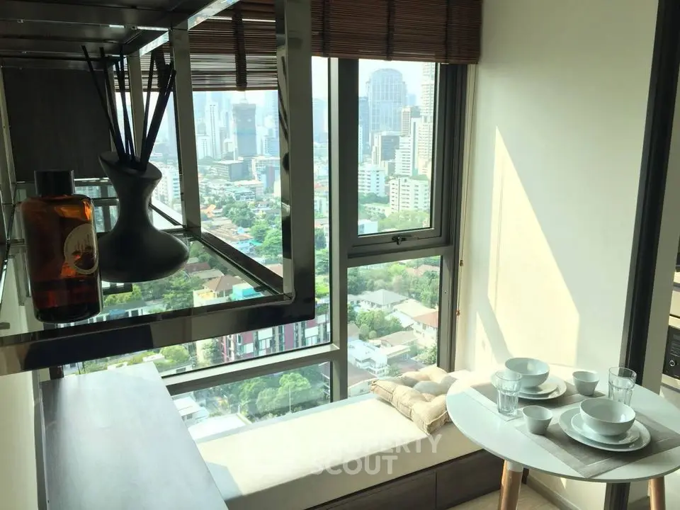 Modern high-rise apartment with stunning city view and cozy dining area.