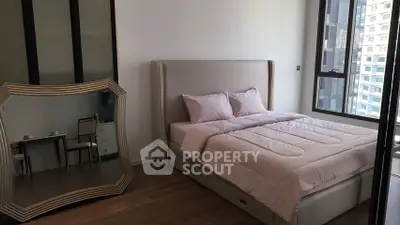 Modern bedroom with elegant decor and large mirror, featuring a comfortable bed and city view.