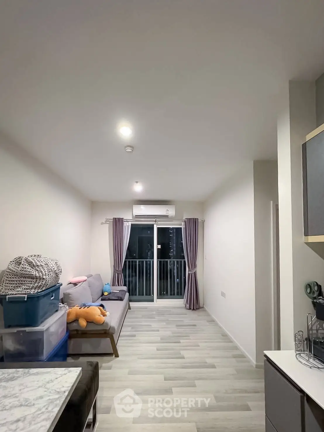 Modern living room with sleek flooring and balcony access, perfect for urban living.